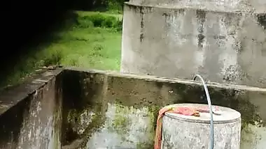 Indian village girl bathing near water tank outdoor